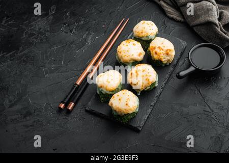 Panini giapponesi di sushi denominati EBI al forno con wasabi e pesce di salmone insieme, su sfondo di pietra nera, con copyspace e spazio per il testo Foto Stock