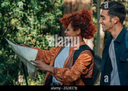 i giovani che viaggiano guardando la mappa all'aperto con zaini Foto Stock