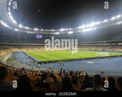 La sera si svolge una grande competizione calcistica in un grande stadio con una luminosa attrazione rimossa dalle tribune Foto Stock