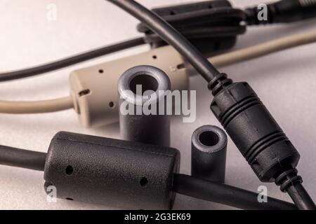 Primo piano di un induttore a perline di ferrite. Elemento elettrico che sopprime il rumore elettronico ad alta frequenza nei circuiti elettronici. Foto Stock