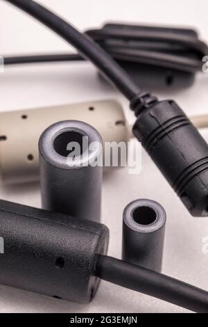 Primo piano di un induttore a perline di ferrite. Elemento elettrico che sopprime il rumore elettronico ad alta frequenza nei circuiti elettronici. Foto Stock