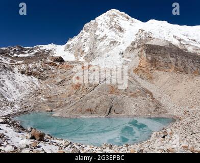 Vista del monte Pumori o Pumo Ri dal campo base di Pumori con lago ghiacciato, parco nazionale Sagarmatha, valle Khumbu, Nepal Foto Stock