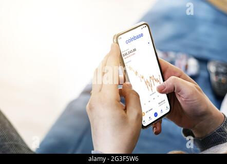 San Francisco, CA, USA, 7 aprile 2021: Donna che controlla le citazioni della criptovaluta sul suo smartphone utilizzando l'app Coinbase. Business e tecnologia. Scang Foto Stock