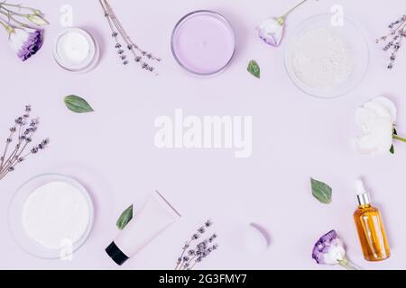 Set relax con cosmetici biologici, candela aromatica, sale da bagno, fiori secchi di lavanda, bottiglia d'olio essenziale, argilla asciutta e idratante su lil leggero Foto Stock