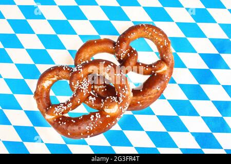 Pretzel salati su sfondo bavarese - pretzel bavarese, pretzel salati su sfondo bavarese a scacchi Foto Stock