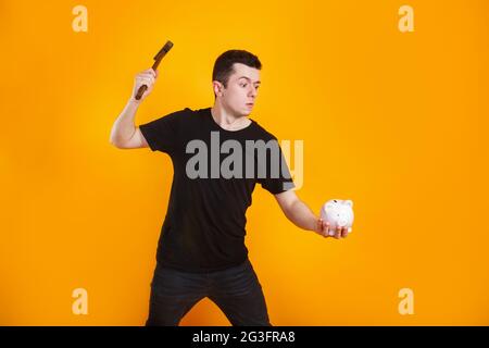 Mano che regge il martello per rompere il salvadanaio - un concetto  finanziario Foto stock - Alamy