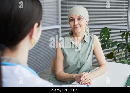 Ritratto di donna matura sorridente che parla con il medico femminile durante la consultazione in clinica, copia spazio Foto Stock