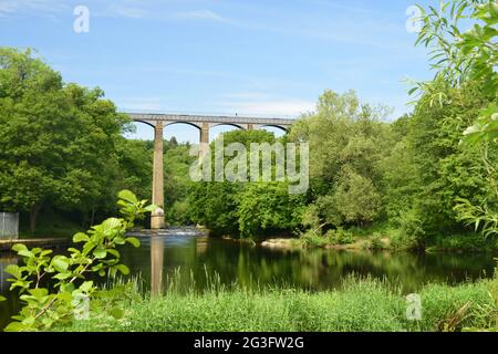 L'imponente acquedotto Pontcysyllte di Thomas Telford si estende sulla valle del fiume Dee, con vista dal fiume e le barche sul canale che attraversano la cima. Foto Stock