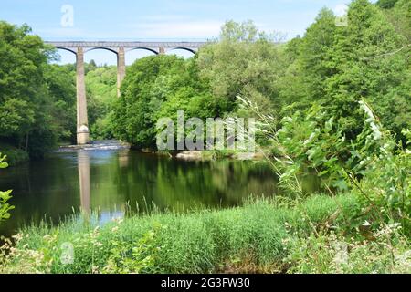 L'imponente acquedotto Pontcysyllte di Thomas Telford si estende sulla valle del fiume Dee, con vista dal fiume e le barche sul canale che attraversano la cima. Foto Stock