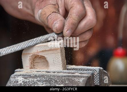 Uomo con le mani del falegname piano su sfondo di legno Foto Stock