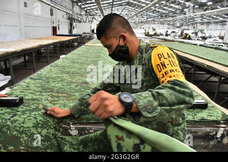 Un lavoratore militare produce uniformi per i membri dell'esercito messicano presso la fabbrica di abbigliamento e attrezzature militari fondata a 1951. I lavoratori militari producono più di 3,000 uniformi al giorno, fabbricate con tessuto da loro fatto per uso esclusivo per l'esercito messicano. Il 15 giugno 2021 a Città del Messico, Messico. (Foto di Eyepix/Sipa USA) Foto Stock