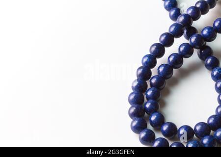 Collana di perle Lapis Lazuli isolata su bianco con spazio per il testo - fuoco selettivo Foto Stock