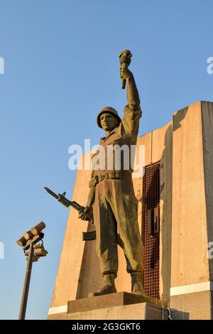 Statua del soldato che tiene una torcia e una pistola nel monumento di Maqam Echahid. Foto Stock