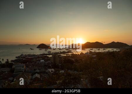 Tramonto sul porto di Labuan Bajo, visto da Puncak Waringin, via Soekarno Hatta, in lontananza, isole Komodo, Indonesia Foto Stock