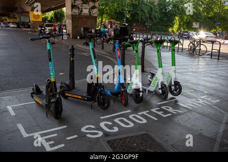 Una stazione e-scooter a Hammersmith - uno dei pochi comuni dove da lunedì 7 giugno 2021 scooter elettrici è diventato disponibile per il noleggio a Londra. Foto Stock