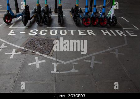 Una stazione e-scooter a Hammersmith - uno dei pochi comuni dove da lunedì 7 giugno 2021 scooter elettrici è diventato disponibile per il noleggio a Londra. Foto Stock