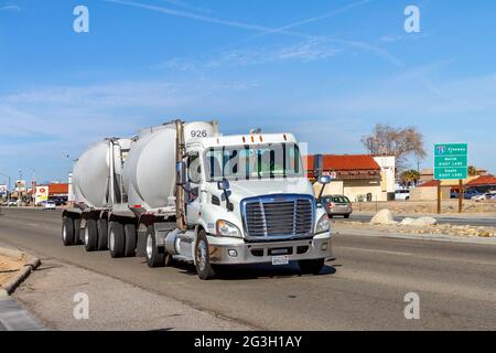 Victorville, CA, USA – 17 marzo 2021: Un semi-camion bianco Apex Bulk Commodities che viaggia su Bear Valley Road a Victorville, California. Foto Stock