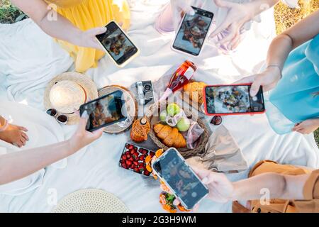 Social Media Content Ideas, Content Creator for Brands, food blog, picnic estivo. Mani femminili, blogger di cibo, creatore di contenuti che prendono foto di cibo via Foto Stock