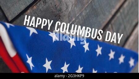 Testo Happy columbus day contro bandiera americana ripiegata su sfondo di legno Foto Stock