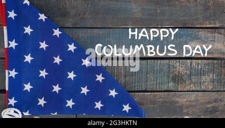 Testo Happy columbus day contro bandiera americana ripiegata su sfondo di legno Foto Stock