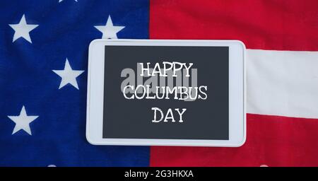 Happy columbus giorno testo su tablet digitale contro bandiera americana in background Foto Stock