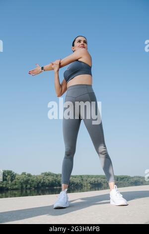 Foto verso l'alto di una giovane donna sicura che fa i suoi tratti. Sopra il cielo blu Foto Stock