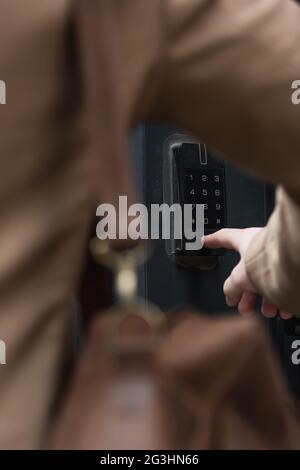 vista parziale di un uomo sfocato premendo il pulsante sulla tastiera dell'interfono Foto Stock