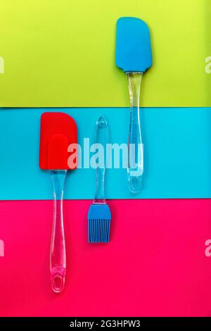 Utensili da cucina in silicone su sfondo tricolore Foto Stock