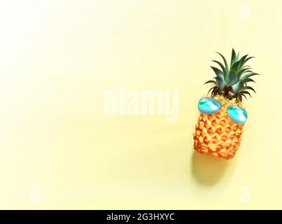 Ananas con occhiali da sole su sfondo giallo. Foto Stock
