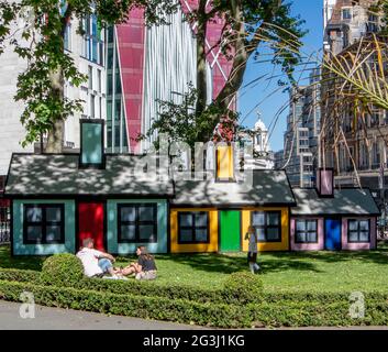 Area giochi per bambini nei Lower Grosvenor Gardens, Victoria, London, UK; una serie di case giocattolo colorate in alta estate, con bambini che giocano intorno a me Foto Stock