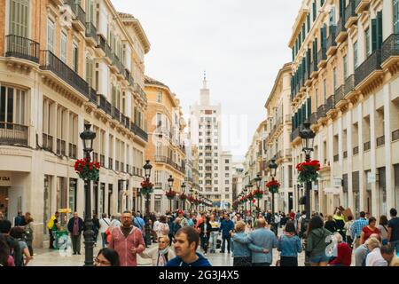 I turisti passeggiano per Calle Marqués de Larios, un esclusivo centro commerciale pedonale ornato a Málaga, in Spagna, e la strada più costosa su cui vivere in città Foto Stock