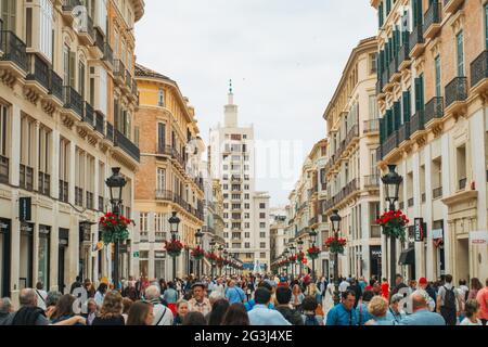 I turisti passeggiano per Calle Marqués de Larios, un esclusivo centro commerciale pedonale ornato a Málaga, in Spagna, e la strada più costosa su cui vivere in città Foto Stock