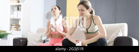 Due donne stanche si siedono sul divano dopo l'allenamento fitness Foto Stock