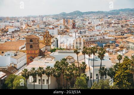 Sbircia attraverso le varie sfumature pastello di bianco, giallo e terracotta della città di Málaga, Spagna Foto Stock