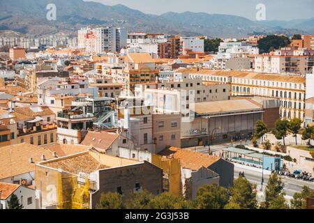 Sbircia attraverso le varie sfumature pastello di bianco, giallo e terracotta della città di Málaga, Spagna Foto Stock