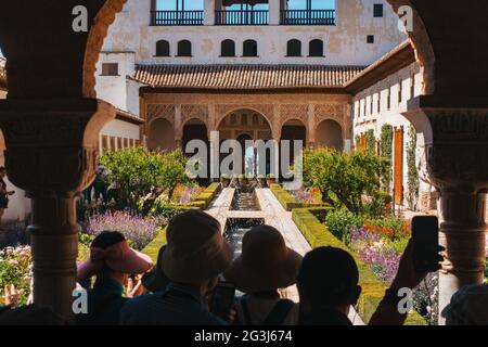 I turisti scattano foto del patio de la Acequia (cortile del canale d'acqua) nel Palazzo Generalife, di fronte all'Alhambra, Granada, Spagna Foto Stock