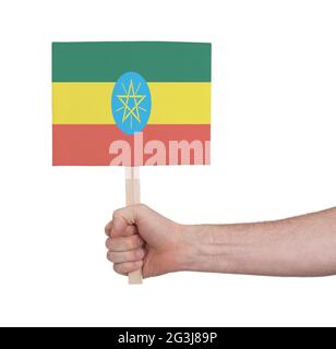 Mano che tiene la piccola carta - bandiera di Etiopia Foto Stock