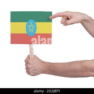 Mano che tiene la piccola carta - bandiera di Etiopia Foto Stock