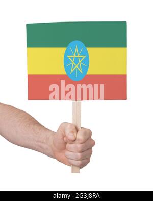 Mano che tiene la piccola carta - bandiera di Etiopia Foto Stock