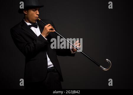 Uomo bello in top hat in posa con la canna da zucchero Foto Stock