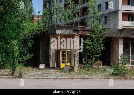 Telefono box vicino abbandonato edificio nel centro della città fantasma Pripyat Chornobyl zona, radiazioni, catastrofa nucleare Foto Stock