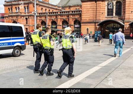 Brema, Germania - 19 agosto 2019: Due poliziotti e una poliziotto e gente intorno davanti alla stazione ferroviaria di Brema (Bremen Hauptbahnhof) in B. Foto Stock