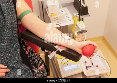 Donatore in poltrona dona sangue Foto Stock
