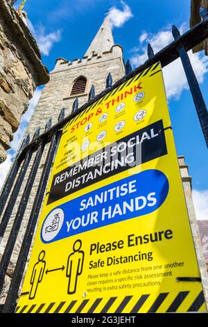 Letterkenny, Contea di Donegal, Irlanda. 16 giugno 2021. La segnaletica su una porta della chiesa ricorda ai visitatori la necessità di una distanza sociale e di igienizzare le mani se desiderano visitare la chiesa. Foto Stock