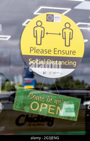 Letterkenny, Contea di Donegal, Irlanda. 16 giugno 2021. La segnaletica su un ristorante da asporto dice "come in We're Open" e un avviso sulla distanza sociale all'interno dell'hotel. Foto Stock