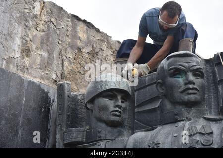 Lviv, Ucraina. 15 giugno 2021. Un lavoratore seghe parti del bassorilievo sul Monumento di Gloria per smantelloWork sulla liquidazione del complesso sovietico del Monumento di gloria militare delle forze armate dell'URSS continua a Lviv. I lavoratori stanno ora smantellando sei bassorilievi di bronzo sulla parete che fa parte del complesso Monumento di Gloria. Tagliarono i bassorilievi in pezzi e poi li trasferiscono al Museo del territorio del Terrore. Il Monumento di Gloria è stato inaugurato a Lviv nel maggio 1970. Credit: SOPA Images Limited/Alamy Live News Foto Stock