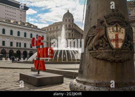 Piazza De Ferrari, la piazza principale di Genova, con la fontana, il logo 'più di questo' e lo stemma della città in primo piano, Liguria, Italia Foto Stock