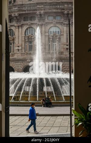 Scorcio di Piazza De Ferrari, la piazza principale di Genova, con la fontana gorgogliante, dall'ingresso di Palazzo Ducale, Liguria, Italia Foto Stock