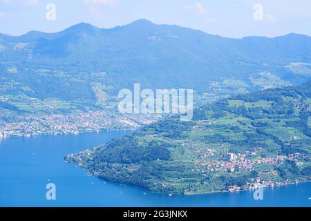 Vista aerea del lago d'Iseo, montagne boscose, vari villaggi sparsi lungo le pendici delle montagne e lungo la costa. Lago d'Iseo in provincia di Brescia Foto Stock