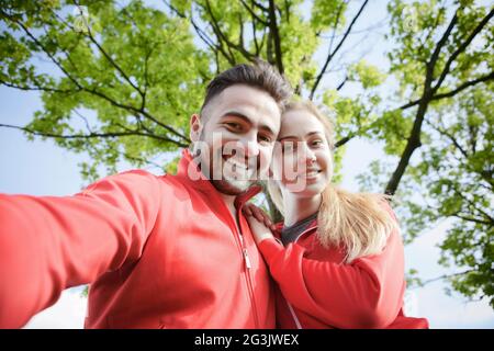 Sport l uomo e la donna che fa selfies in posizione di parcheggio Foto Stock